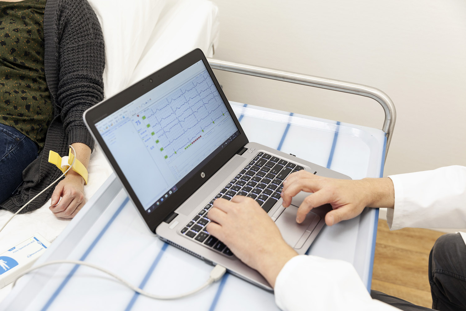 Doctor with laptop checking patient's heart rate