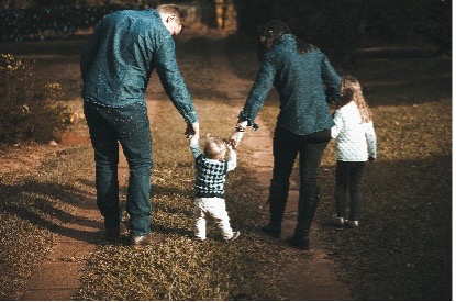 A couple walking with a child in the middle, holding hands