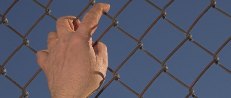Picture of a migrant climbing a fence