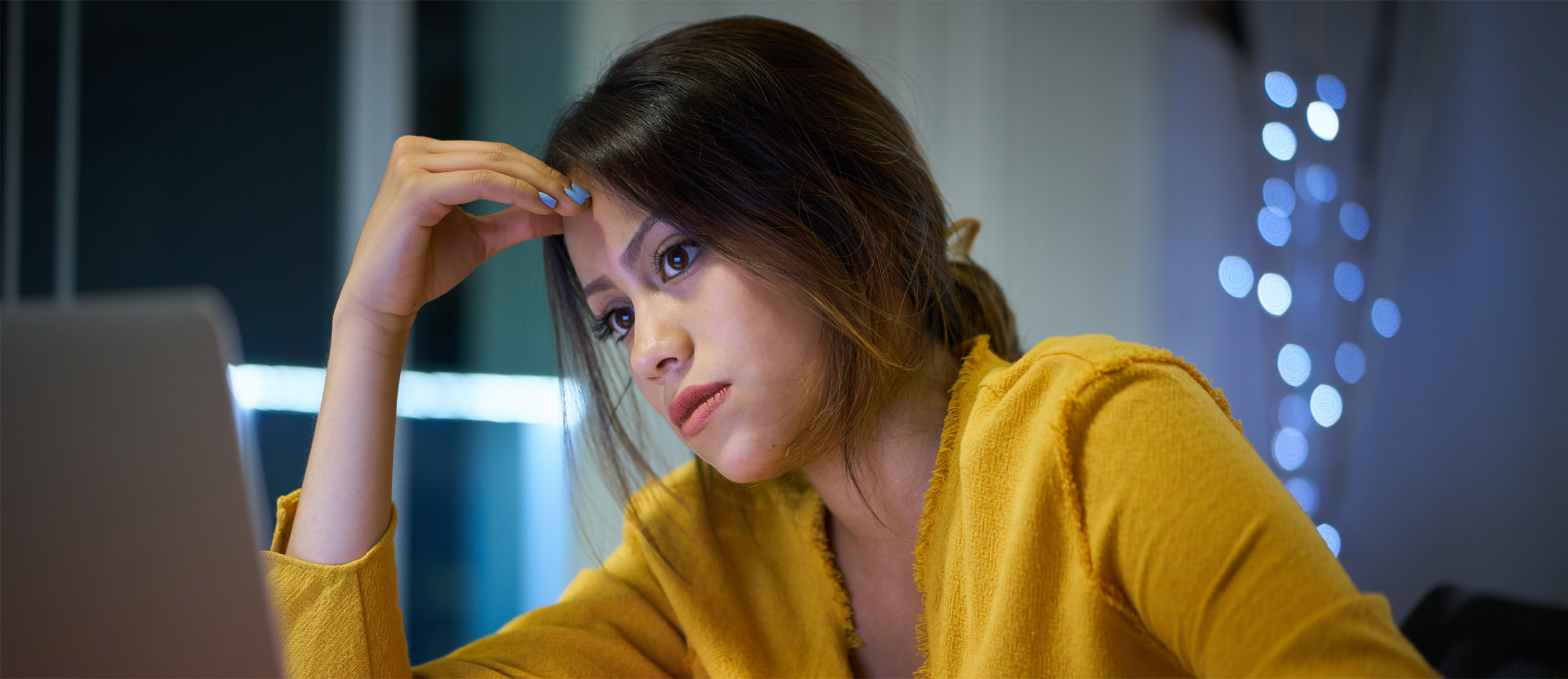 Worried young woman looking at laptop screen