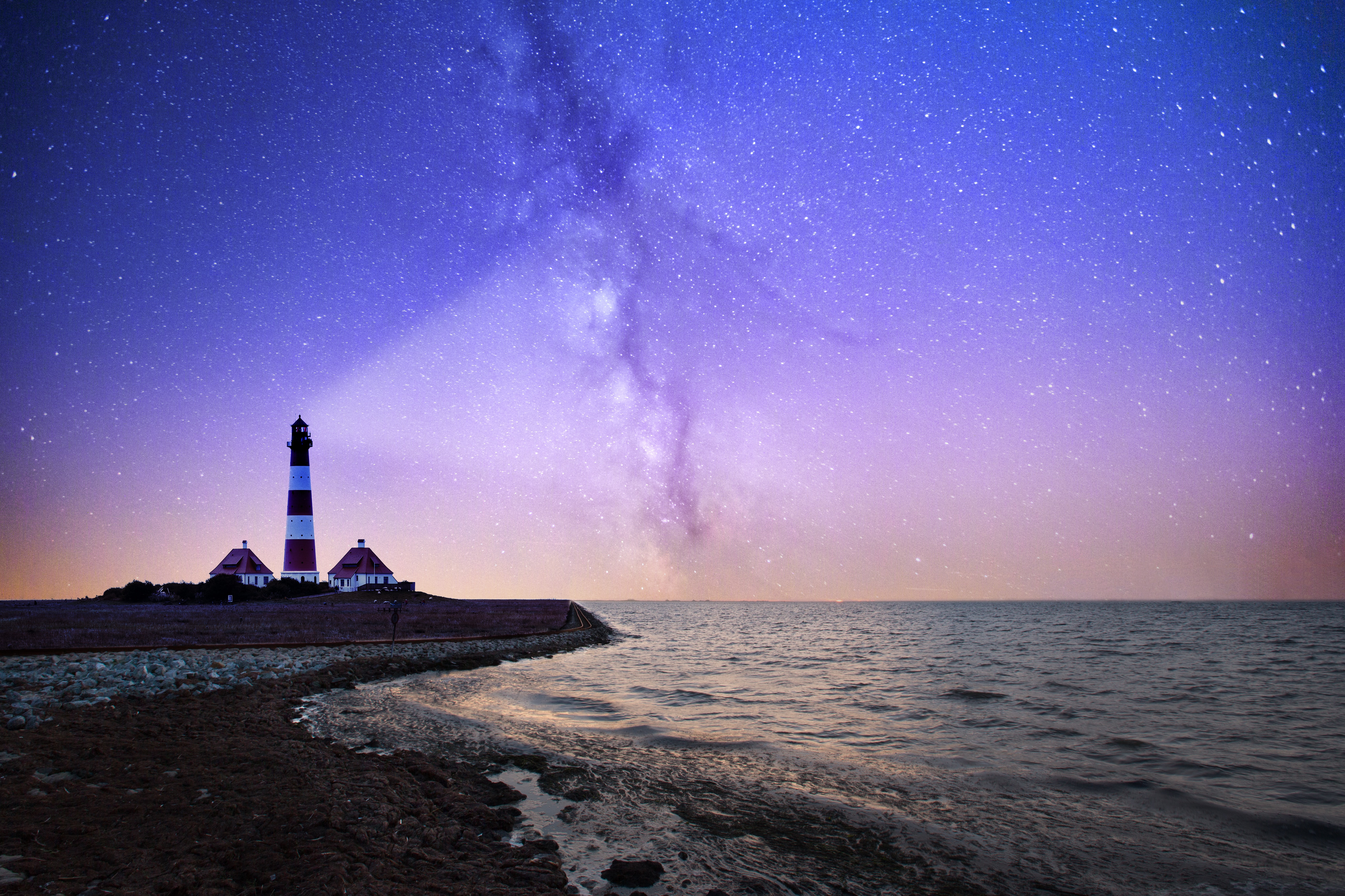lighthouse underneath a starry sky