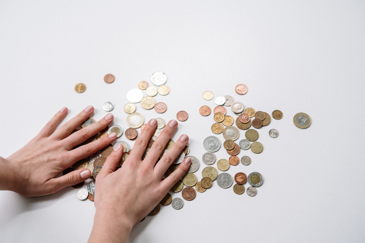 two hands shuffeling a pile of small change