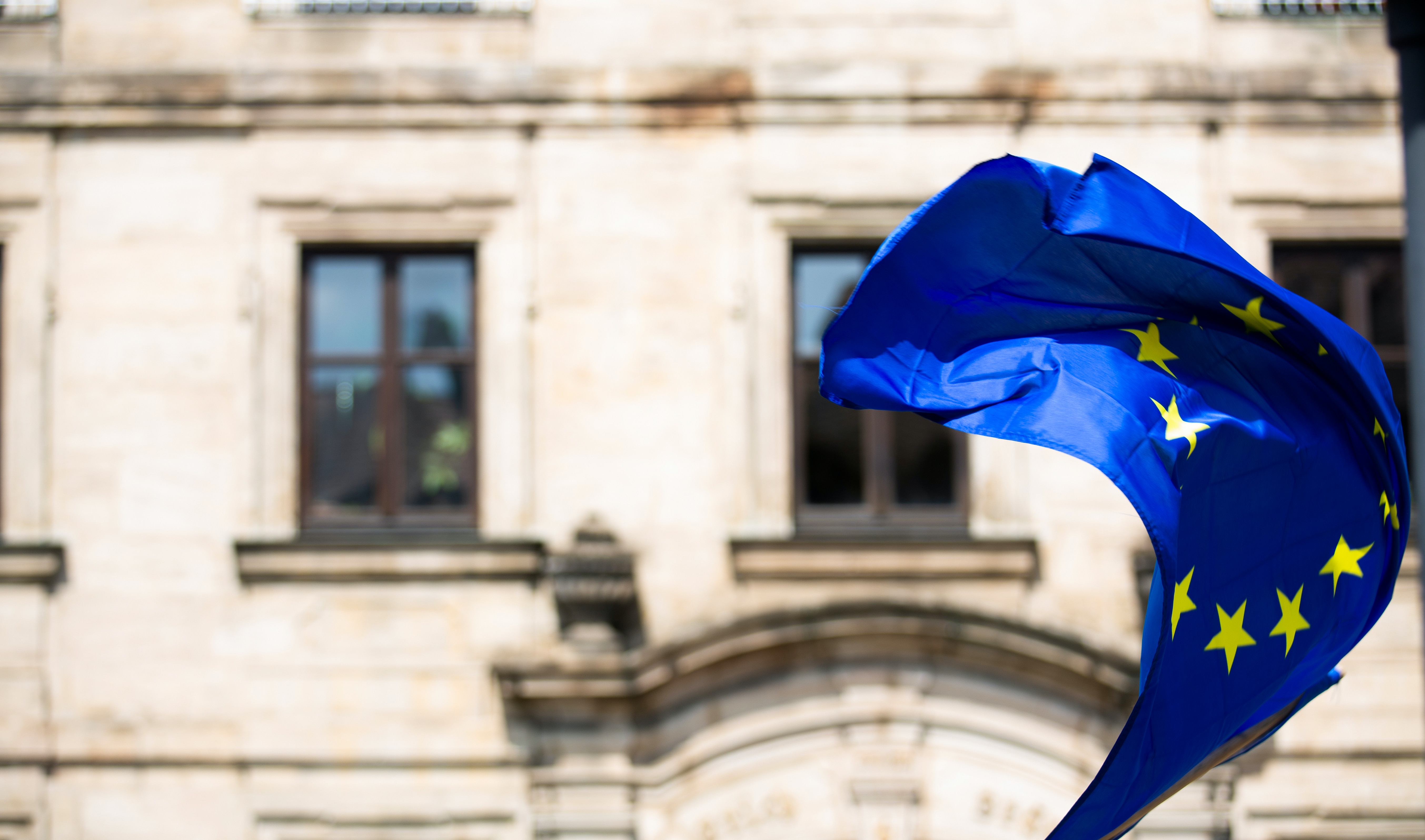 European Flag waving in the wind in front of a building