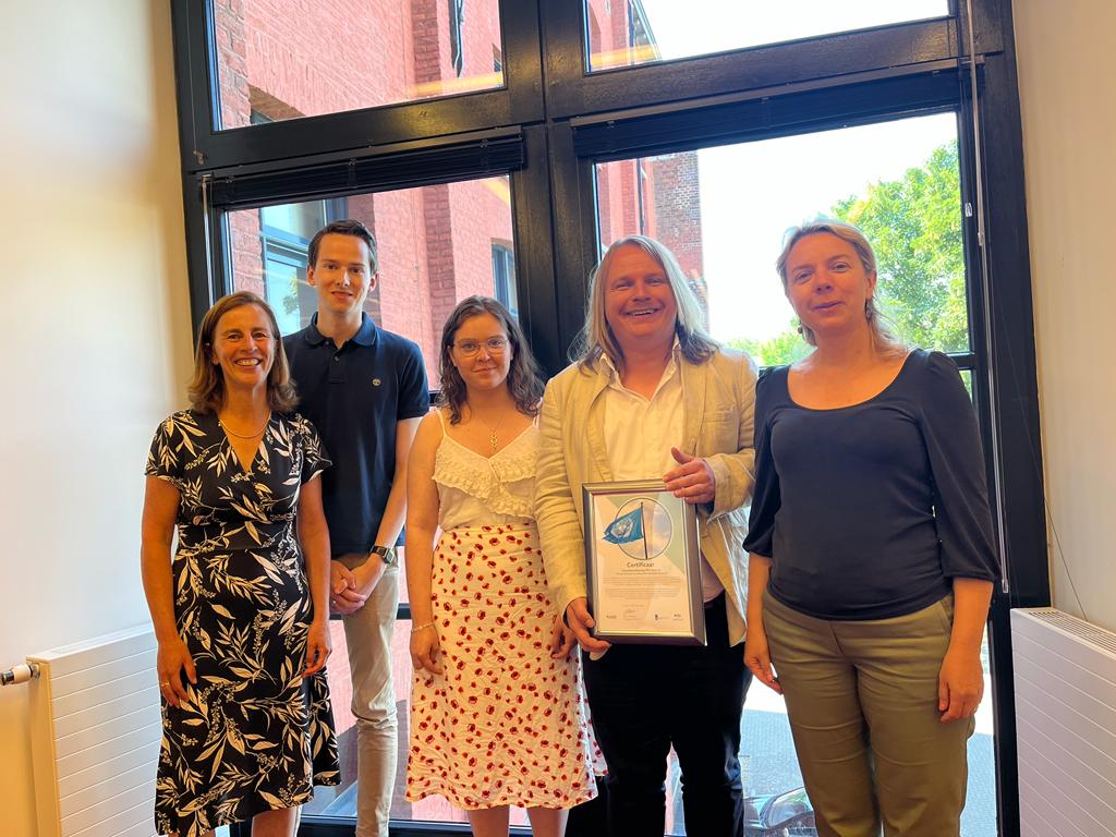 A photo of Sigrid from Disability Support, Sjoerd, John and Carolina from UnliMited-Students and Prof. dr. Pamela Habibović, smiling and holding the UN Declaration of intent. 