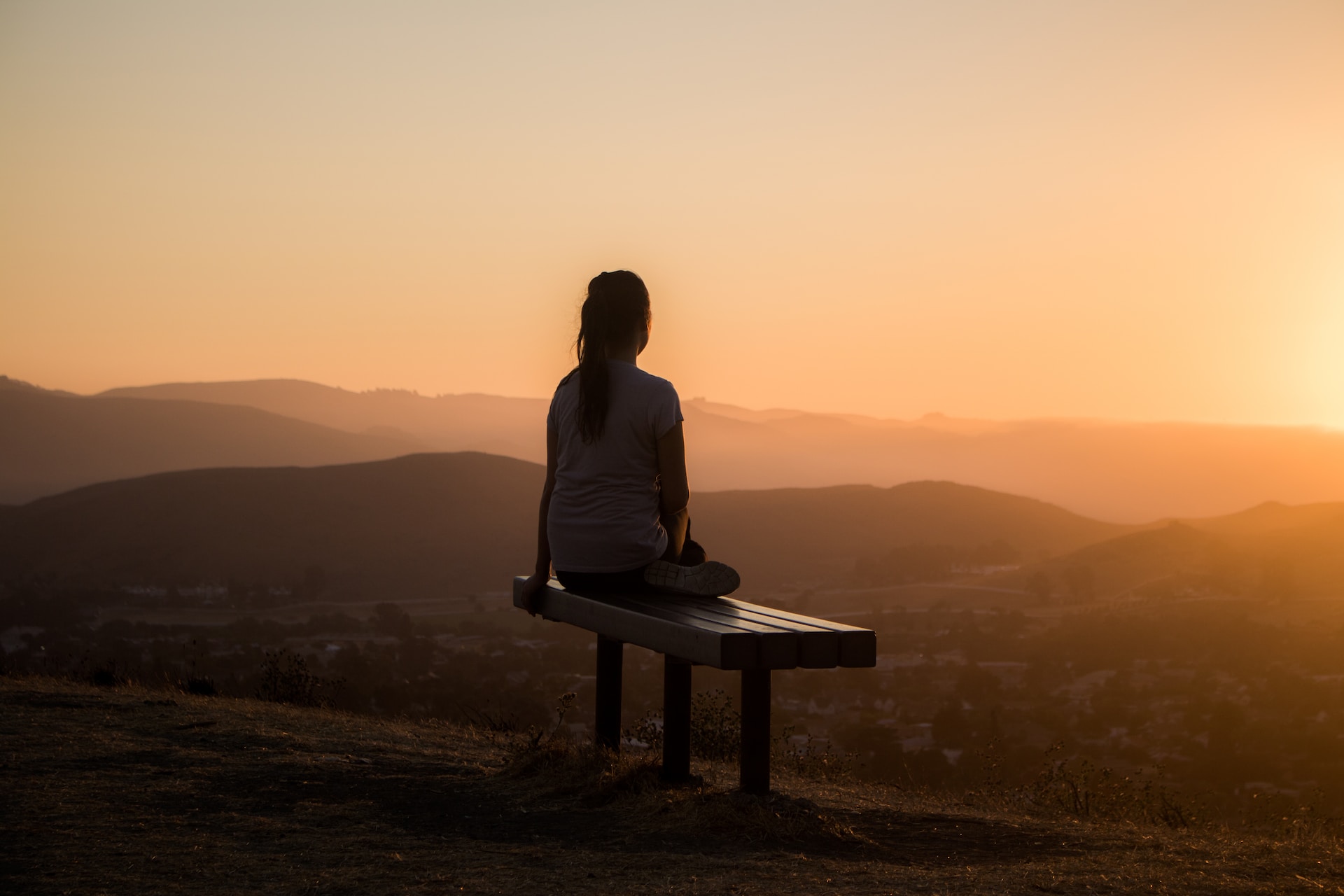 Woman on bench at dawn - Photo by Sage Friedman on Unsplash