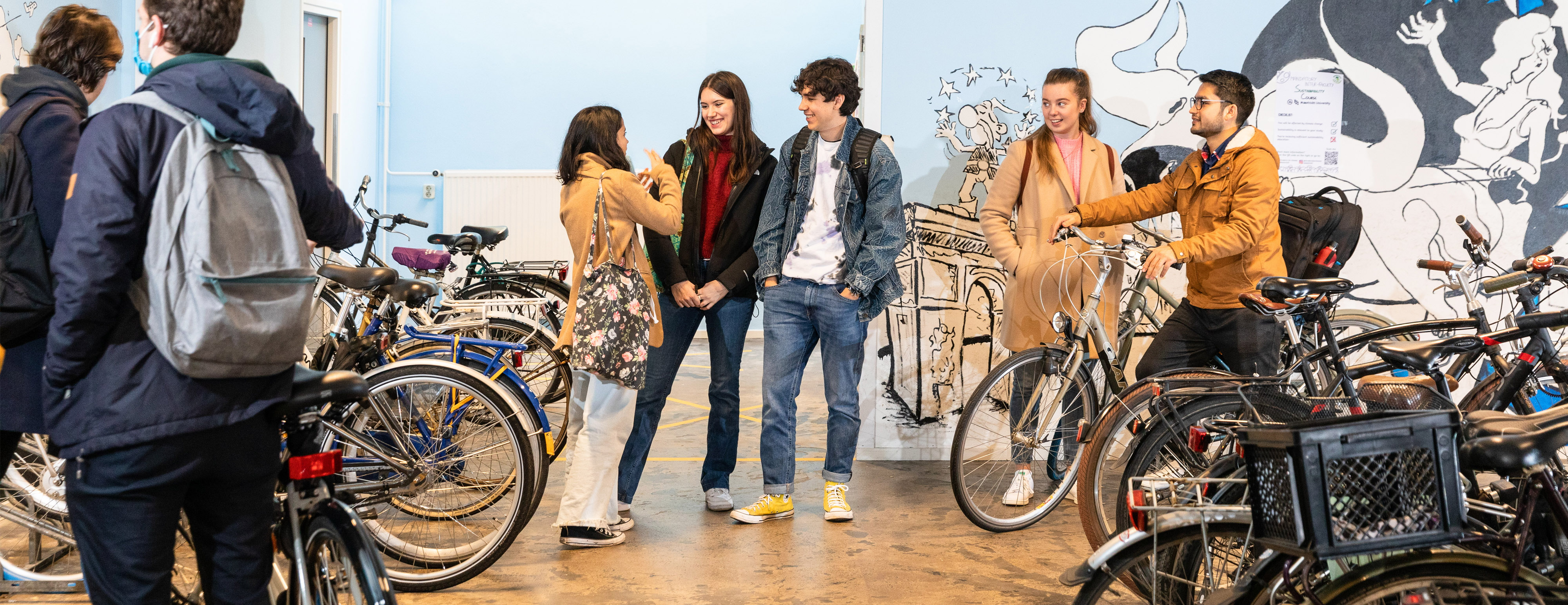 Students standing at bicycle rack, chatting 