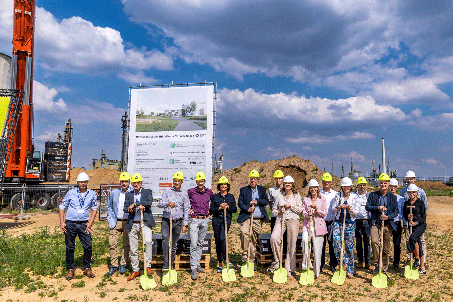 Corporate people in hard hats standing at construction site
