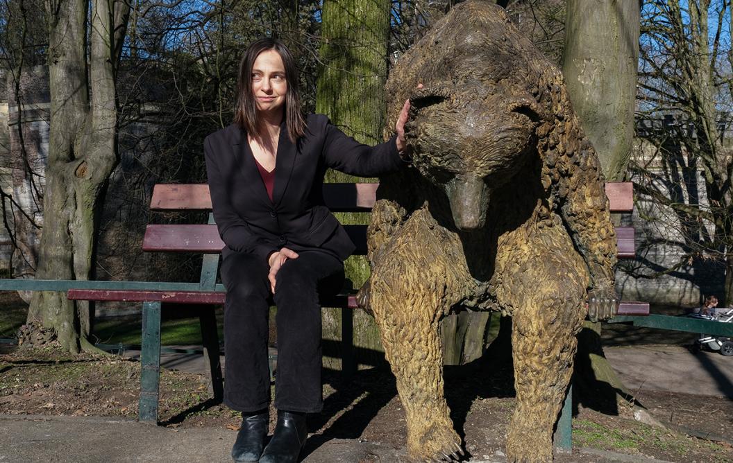 Kateřina Staňková sitting next to bear statue