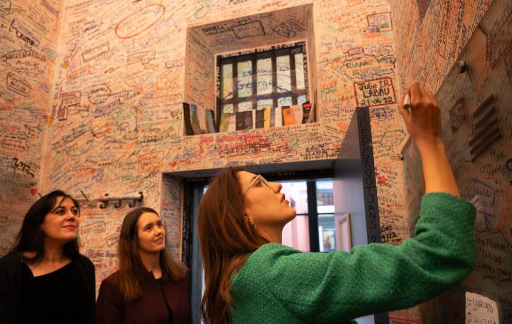 Cenay Akin writing her name on the wall after her PhD defence