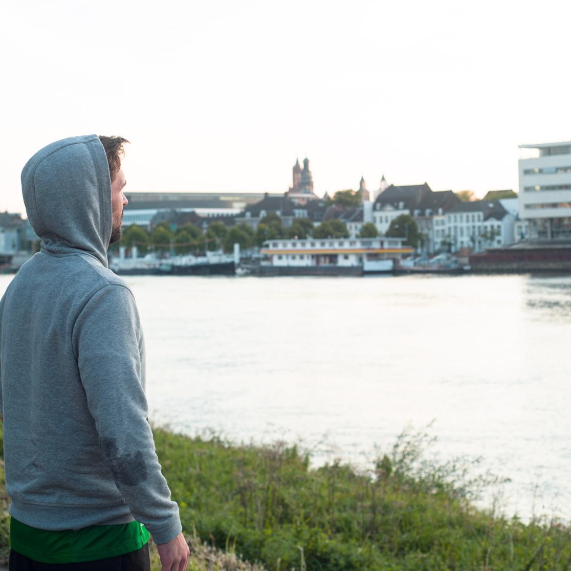 Young man looking out over the river Meuse