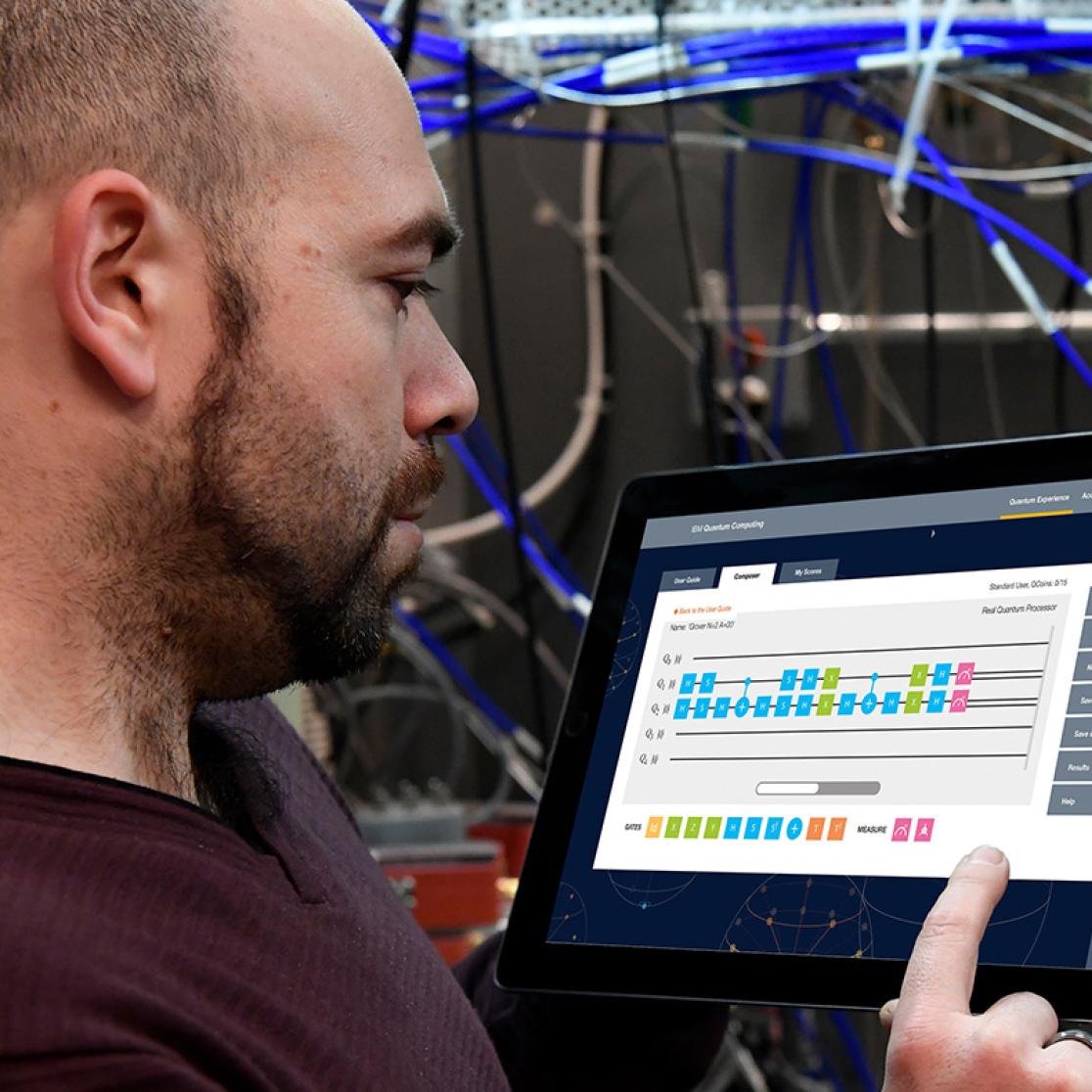 Man working on tablet near quantum computer