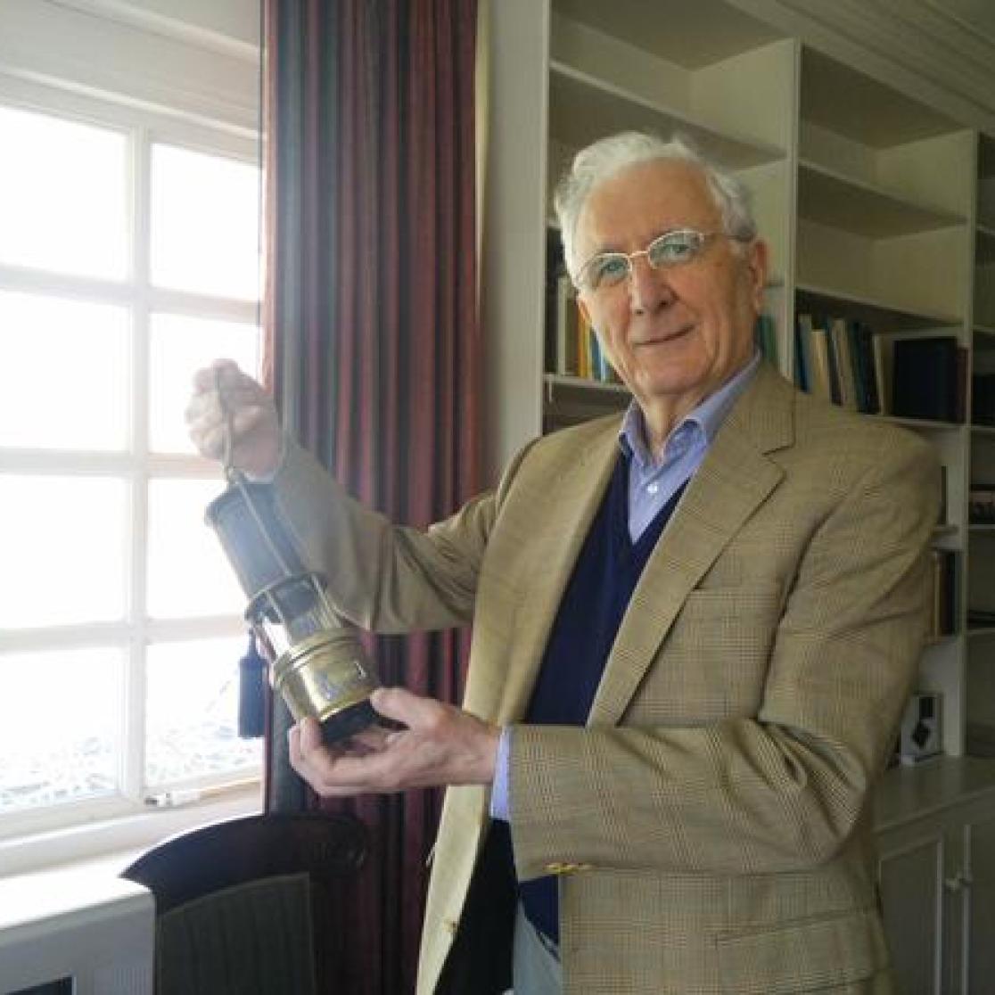 A picture of Sjeng Kremers holding a lamp used in the mines.