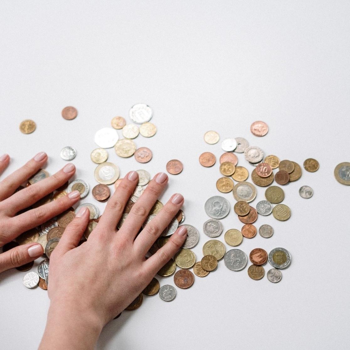 two hands shuffeling a pile of small change