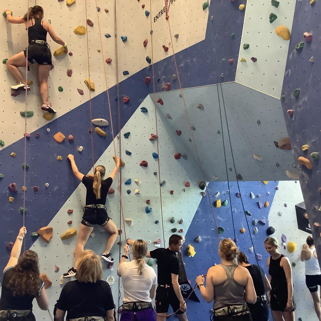 Students climbing up a climbing wall