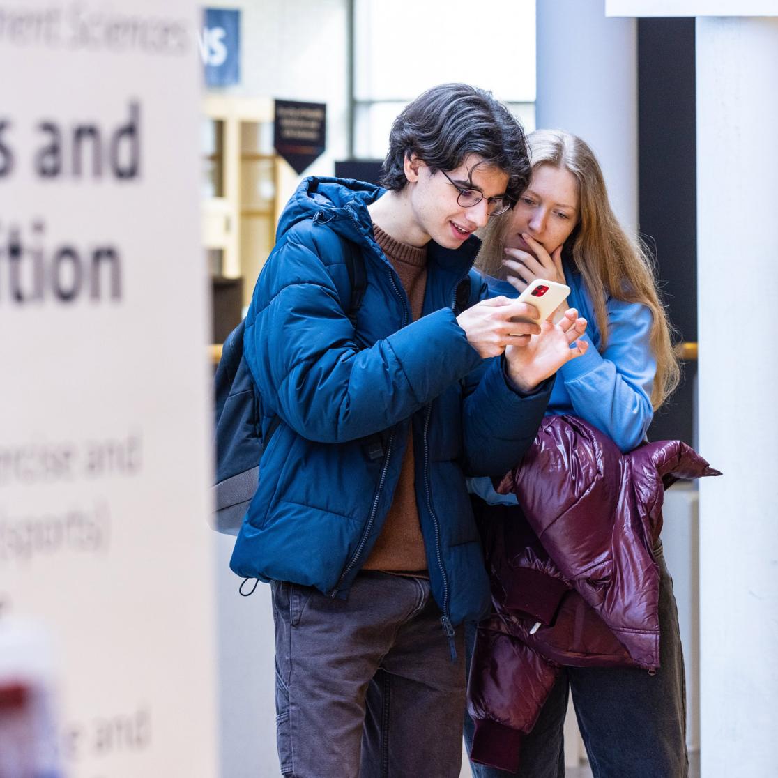 Two students looking at a phone together