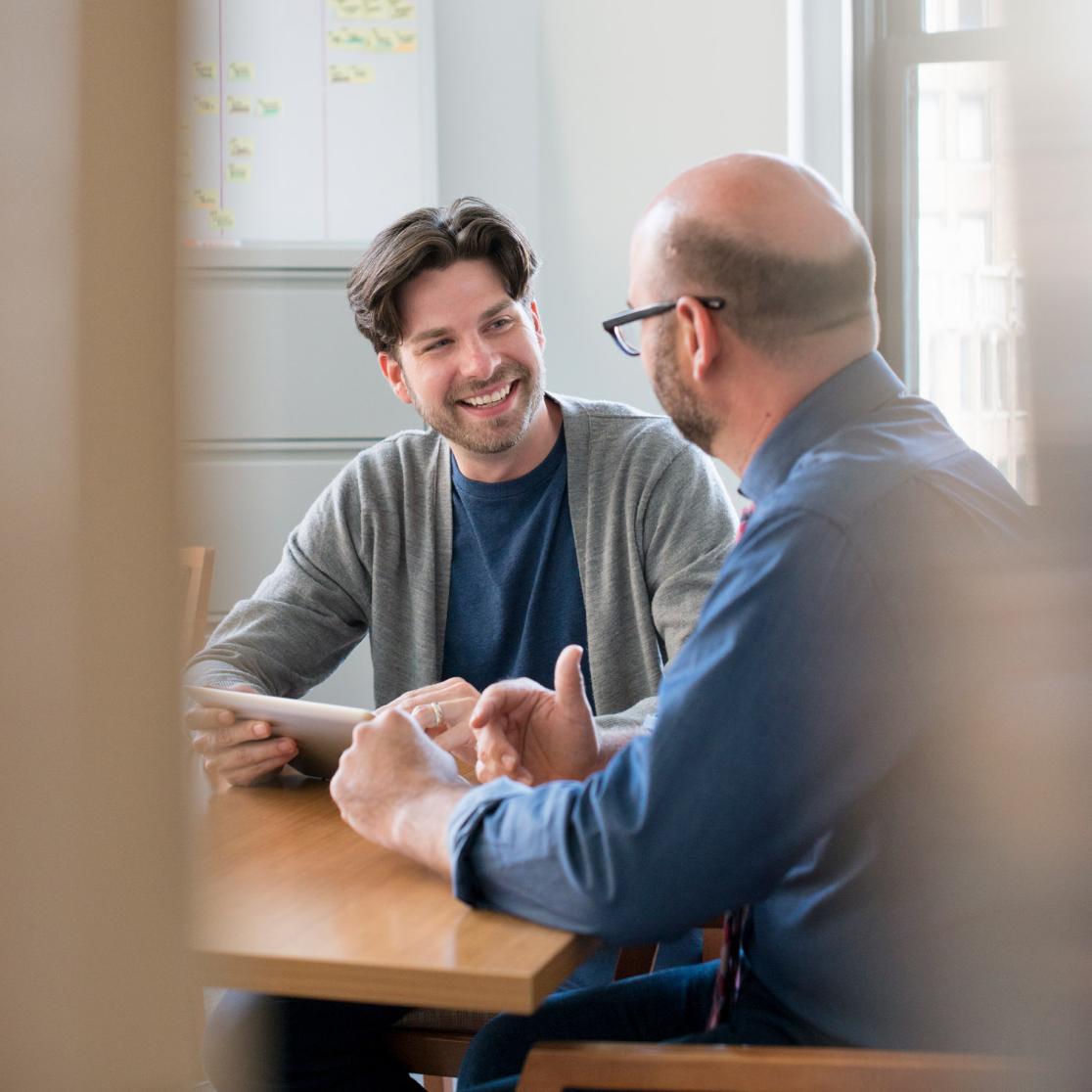 Two people at a table talking to eachother