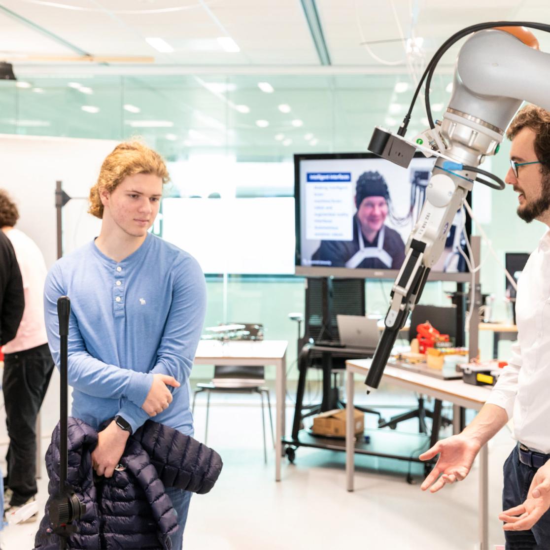 Prospective students looking at a robot at a UM Open Day