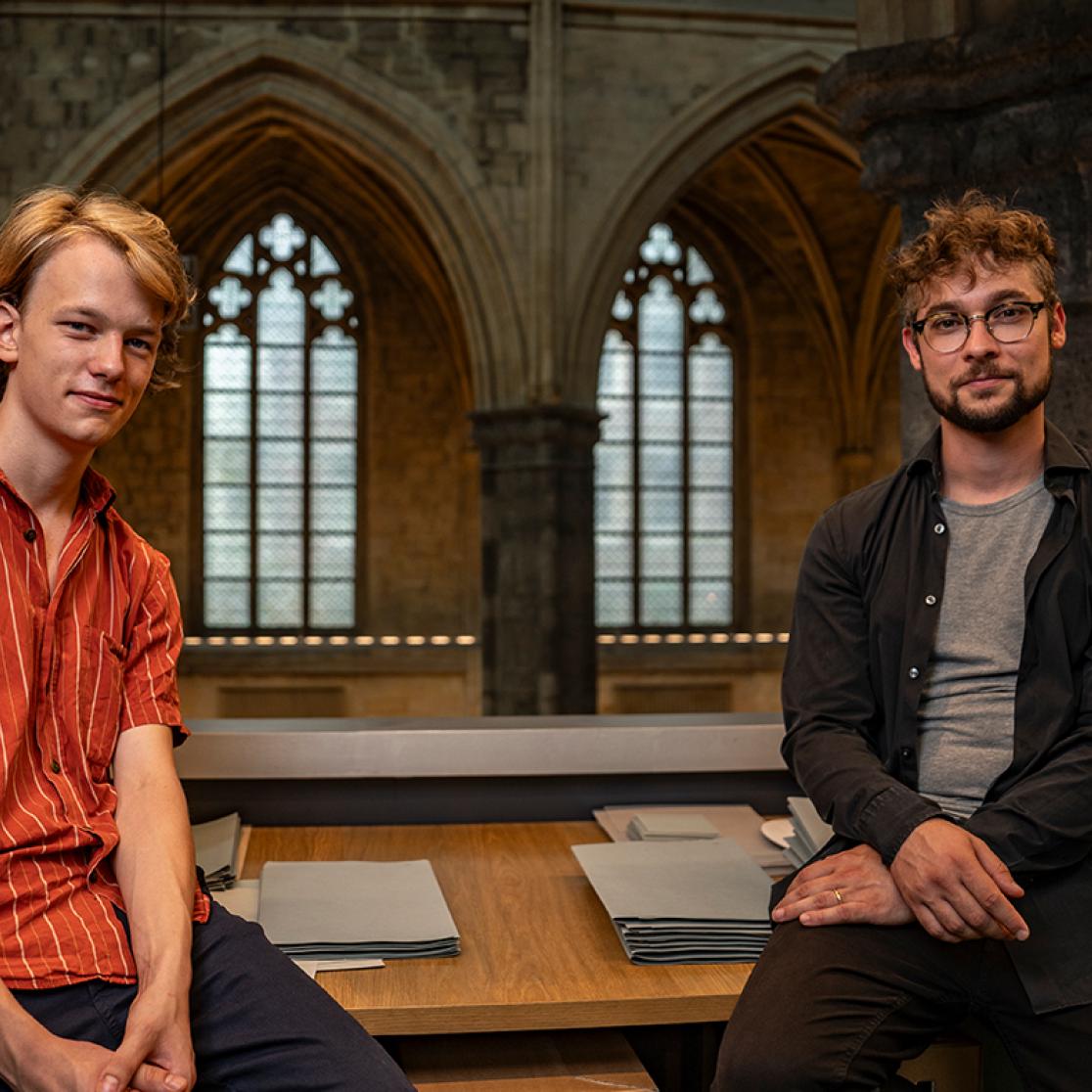 Two guys sitting on desk
