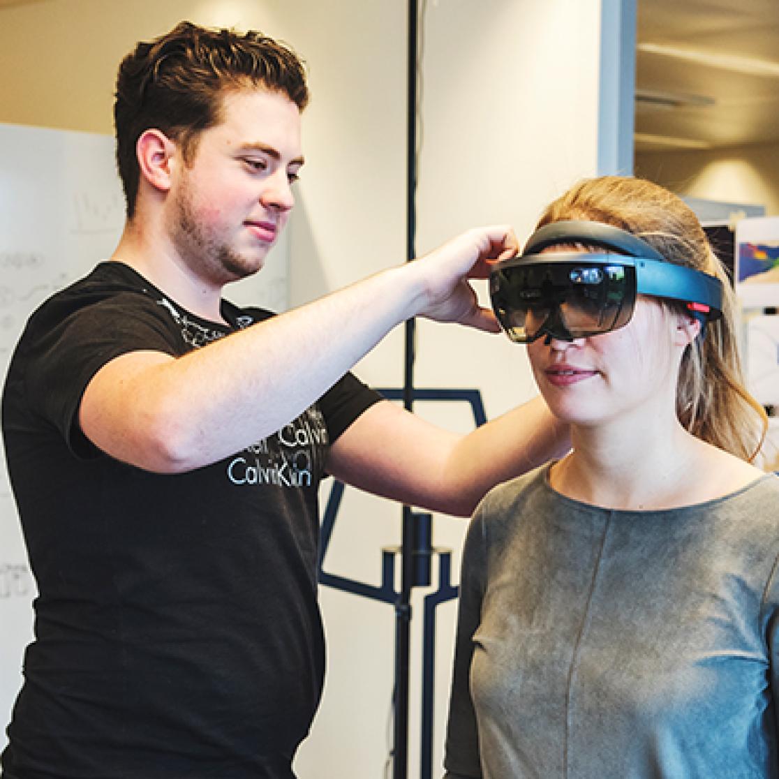 Guy puts VR goggles on girl