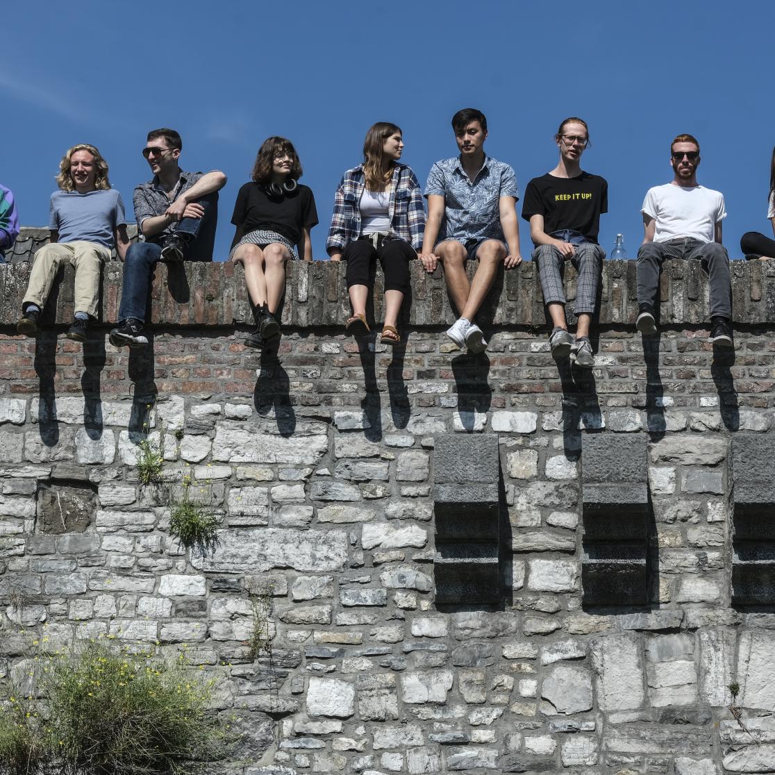 Student relaxing on city wall