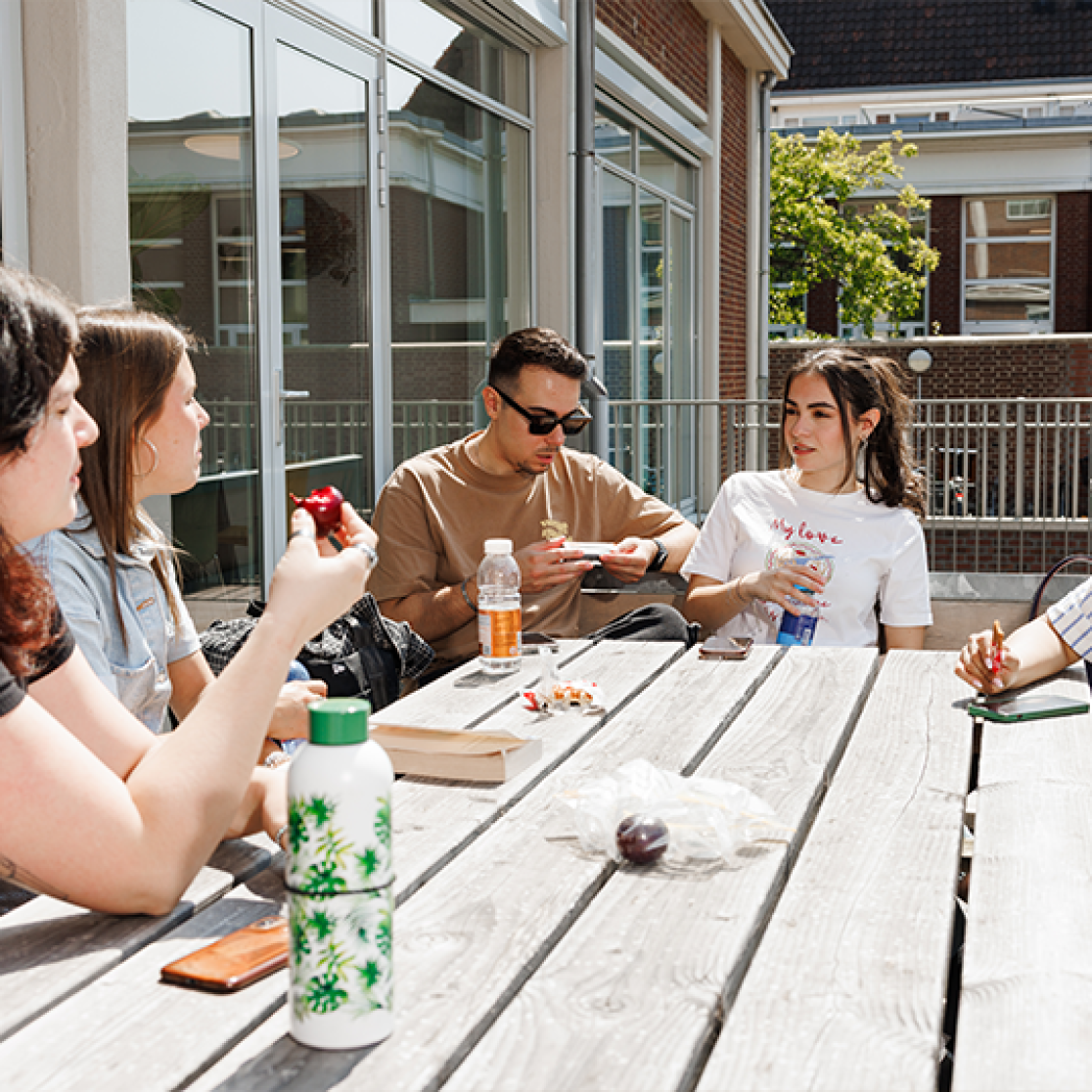Students chilling out outside at a picknick table