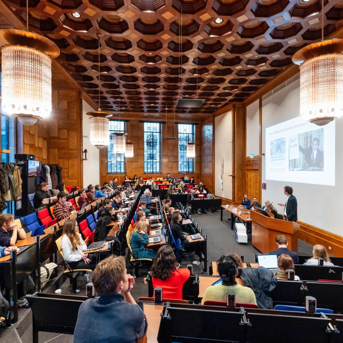 a room with people listening to a lecture