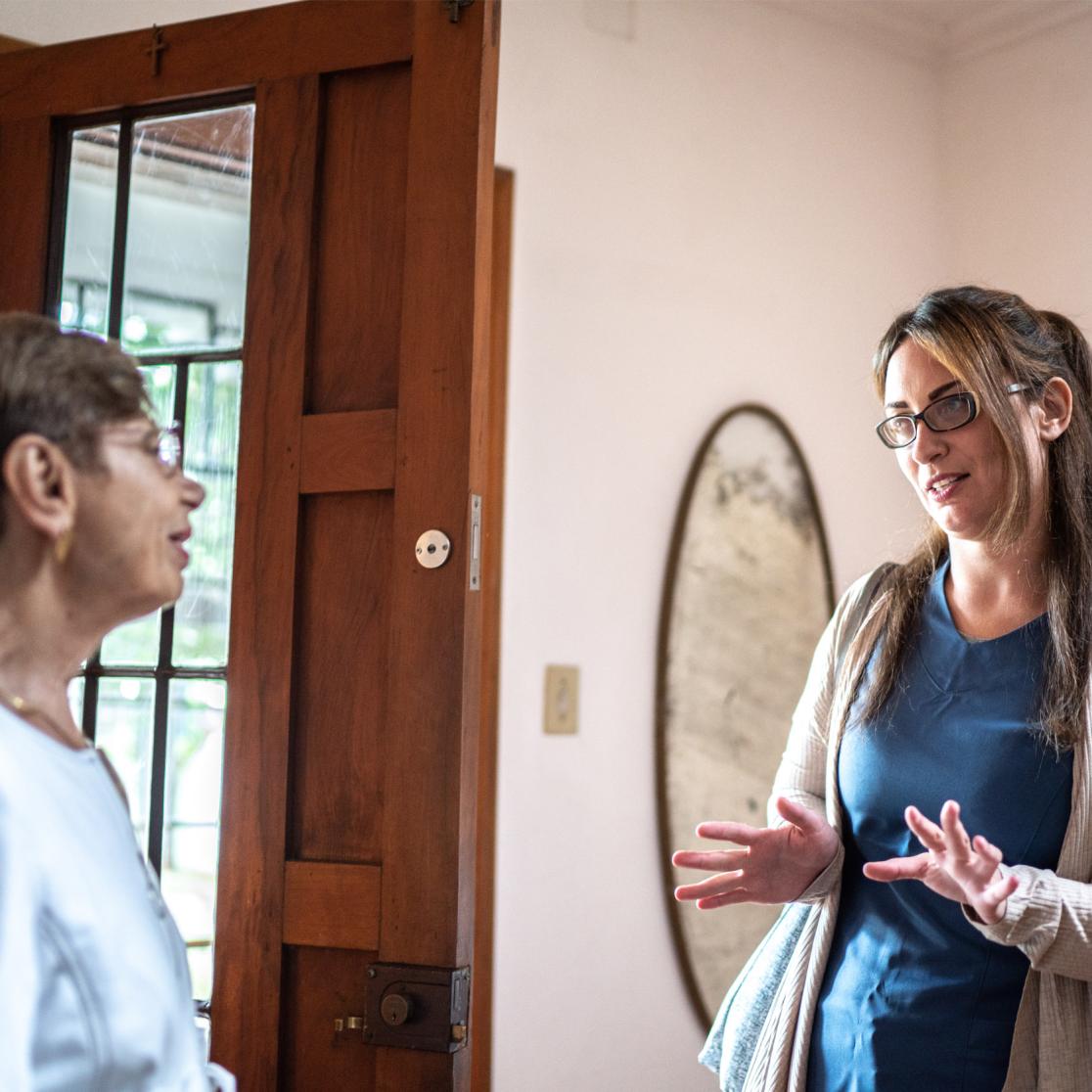 Volunteer interviewing a patient at her home