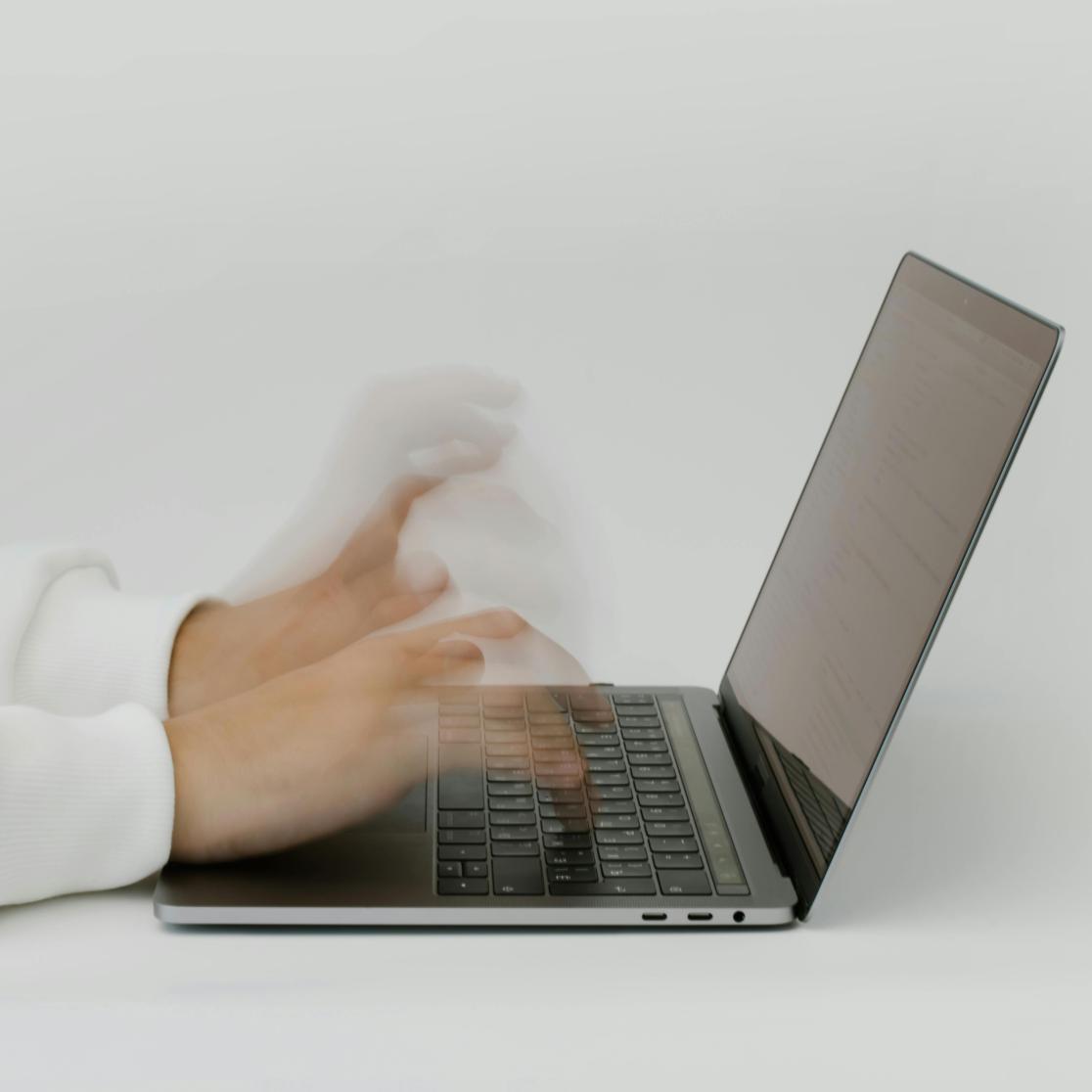 hands moving over laptop keyboard