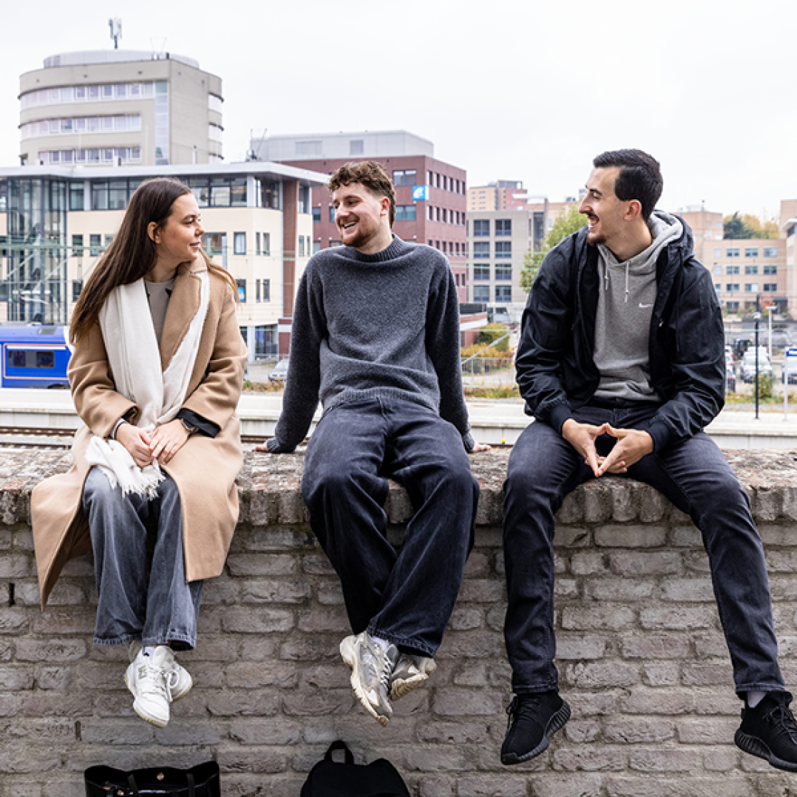 Students sitting on brick wall