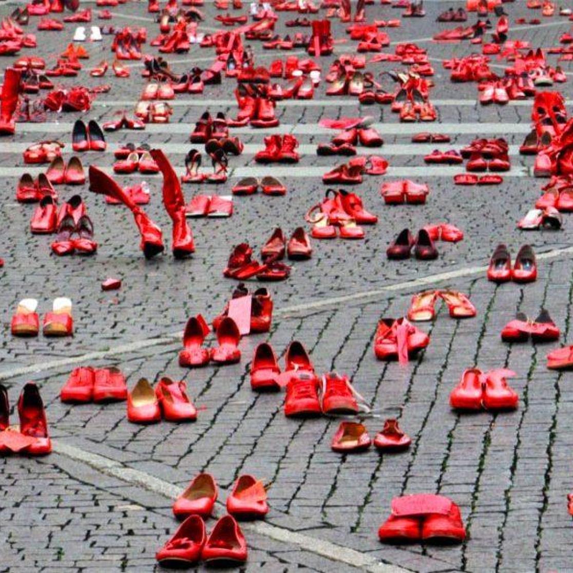 Red women's shoes on a square as a protest against femicide