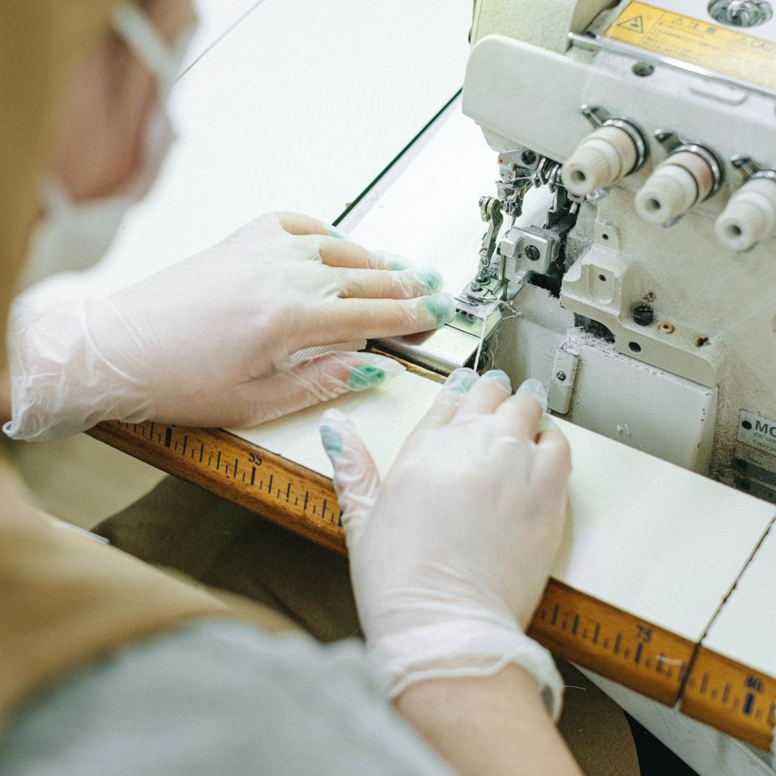 Person sewing fabric with sewing machine