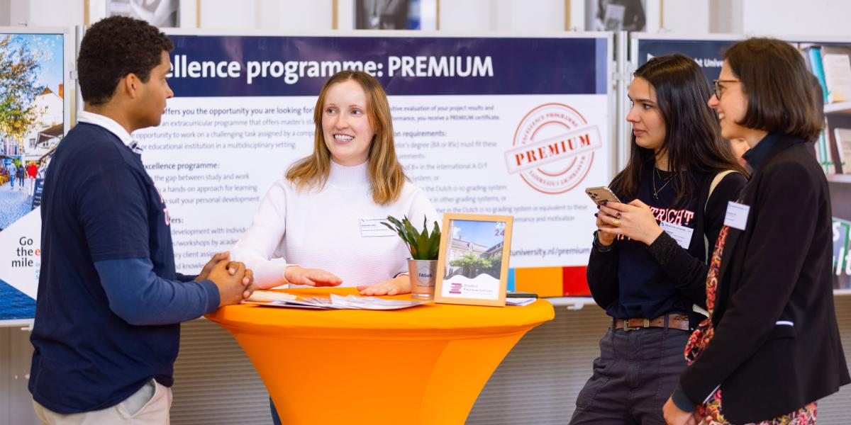 Students discussing the PREMIUM excellence programme at an information booth