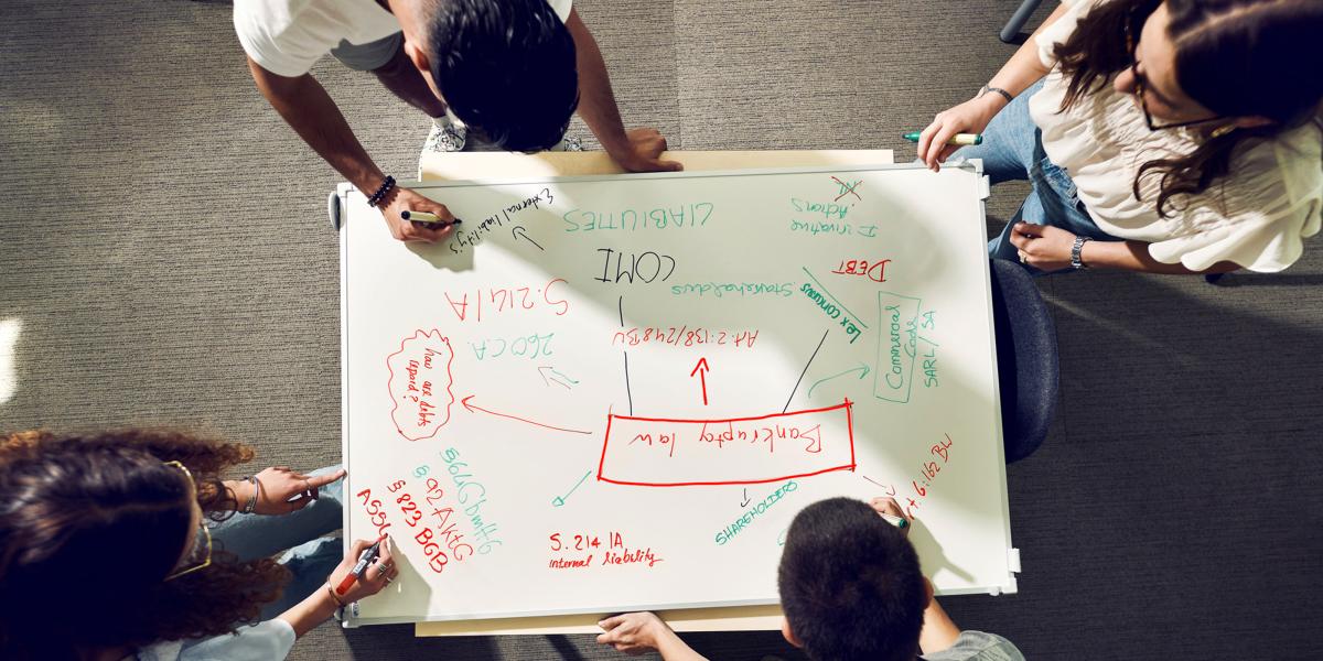 PBL: helicopter view of 4 students writing on a white board