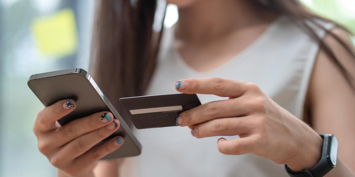 Woman holding a smartphone and credit card for online payment