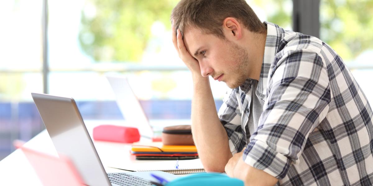 Frustrated student looking at his laptop