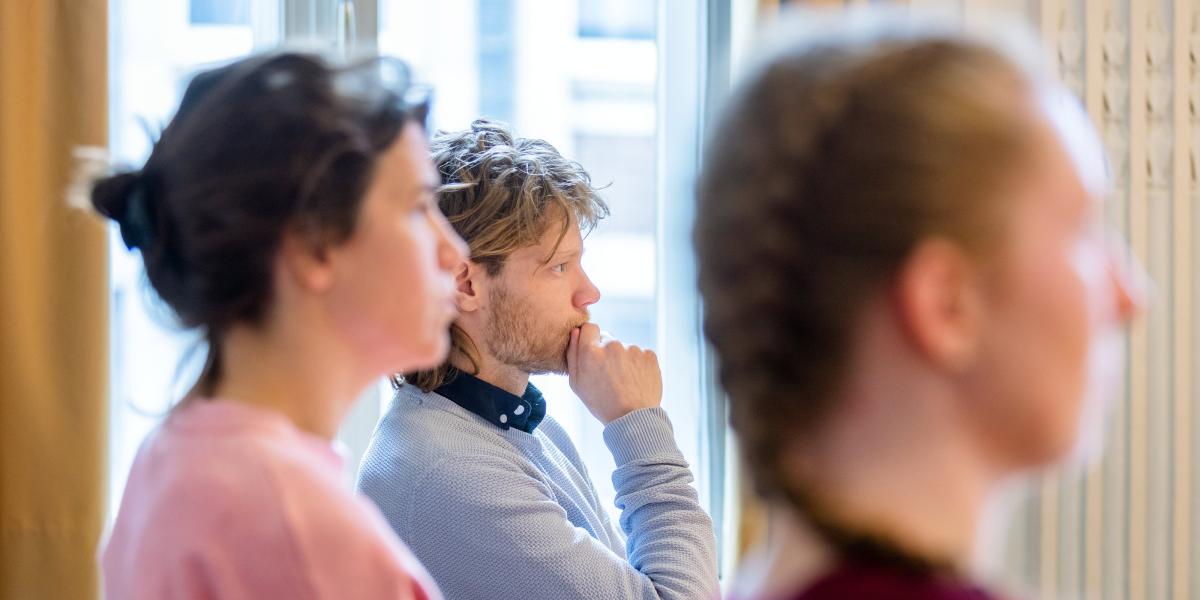 Three students listening attentively in a classroom