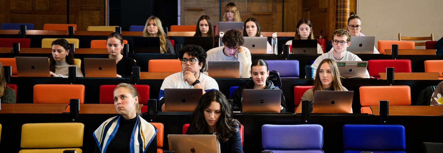 Studenten volgen college in de Statenzaal van de faculteit en maken aantekeningen op hun laptops.