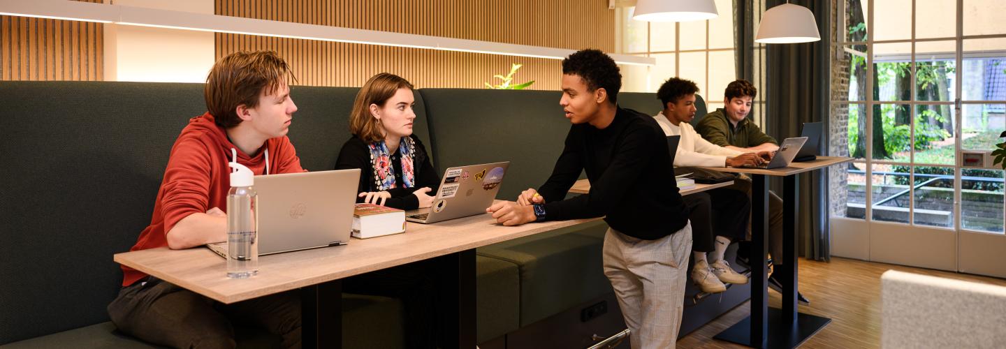 Students are discussing at a high study table in the faculty’s learning space, overlooking the inner courtyard.