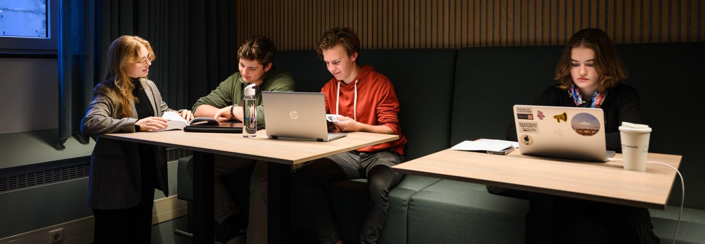 A student explains something to two peers, while another student is working with focus in the faculty’s learning space.