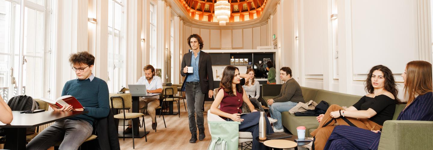 Studenten ontspannen, werken en praten met elkaar in een stijlvolle gemeenschappelijke ruimte met hoge plafonds en kroonluchters.