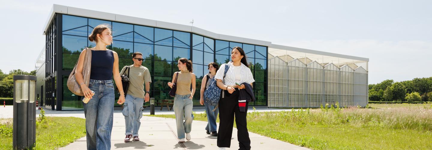 Students walking in front of the research greenhouse in Venlo