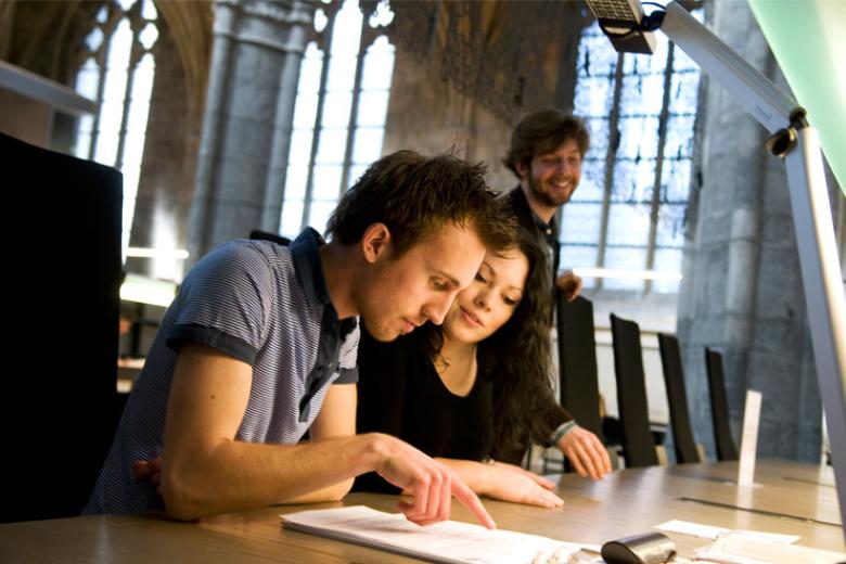 Two students studying together in a library.