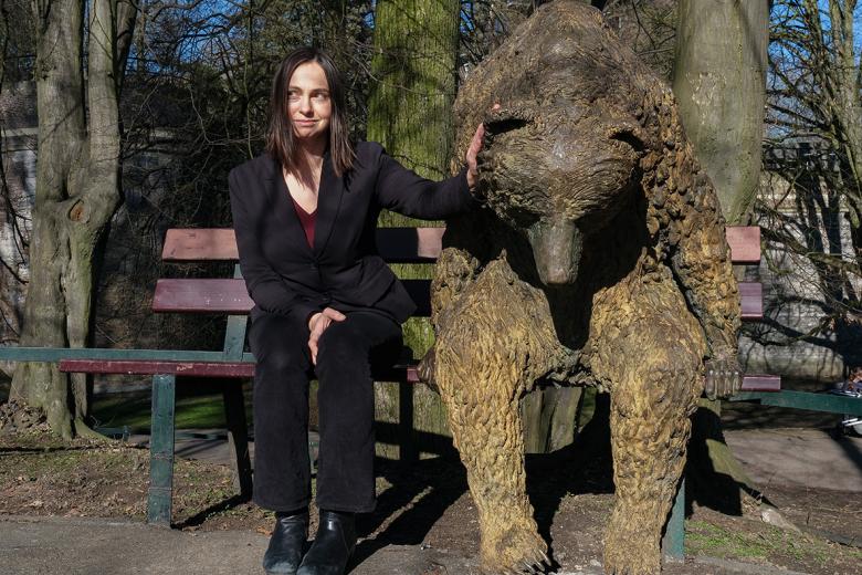 Kateřina Staňková sitting next to bear statue