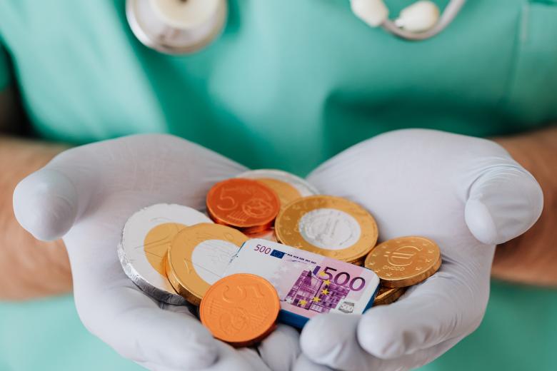 Healthcare Policy, Innovation and Management: chocolate coins in a doctor's hand