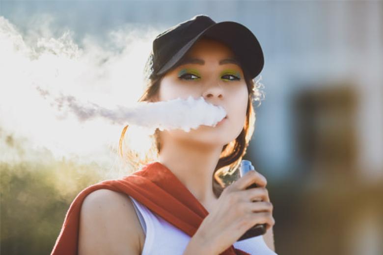 Young woman smoking an e-cigarette