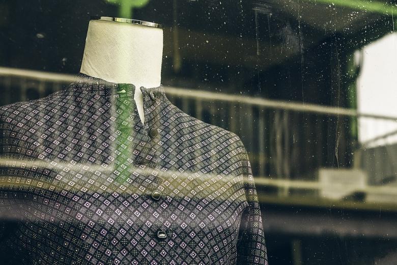 a mannequin wearing a blouse in a window