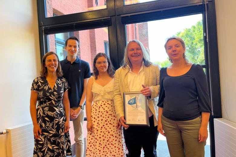 A photo of Sigrid from Disability Support, Sjoerd, John and Carolina from UnliMited-Students and Prof. dr. Pamela Habibović, smiling and holding the UN Declaration of intent.