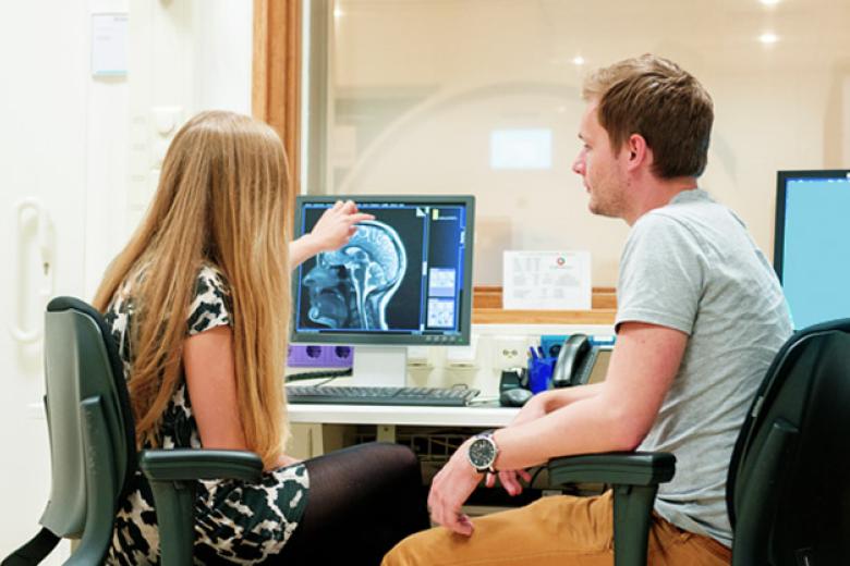 A woman explaining a brain scan to a man