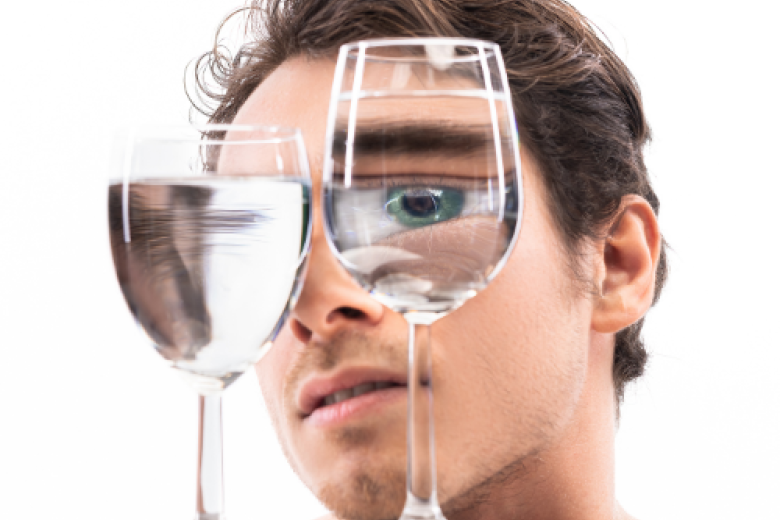 Man looking at wine glasses filled with water