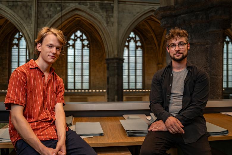 Two guys sitting on desk
